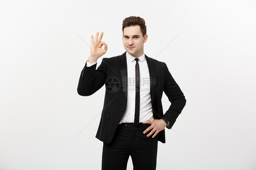 商业概念穿智能西装的帅哥孤立在灰色背景上显示好牌子孤立在灰色背景上显示好牌子图片