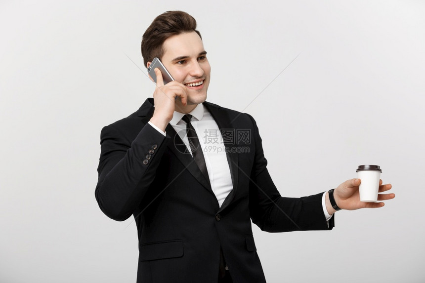 商业概念有自信的年轻英俊商人在手机上交谈白色孤立的背景下喝咖啡图片