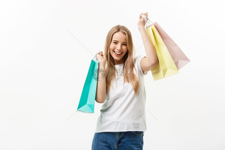 购物和生活方式概念年轻快乐的夏季购物妇女微笑并持有白色背景孤立的购物袋和生活方式概念年轻快乐的夏季购物妇女微笑并持有白色背景孤立图片