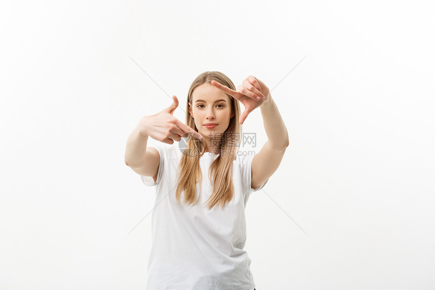 年轻美丽的causin女子肖像笑的容用手指制作相机框孤立在白色背景上复制空间年轻美丽的causin女子的肖像复制空间图片