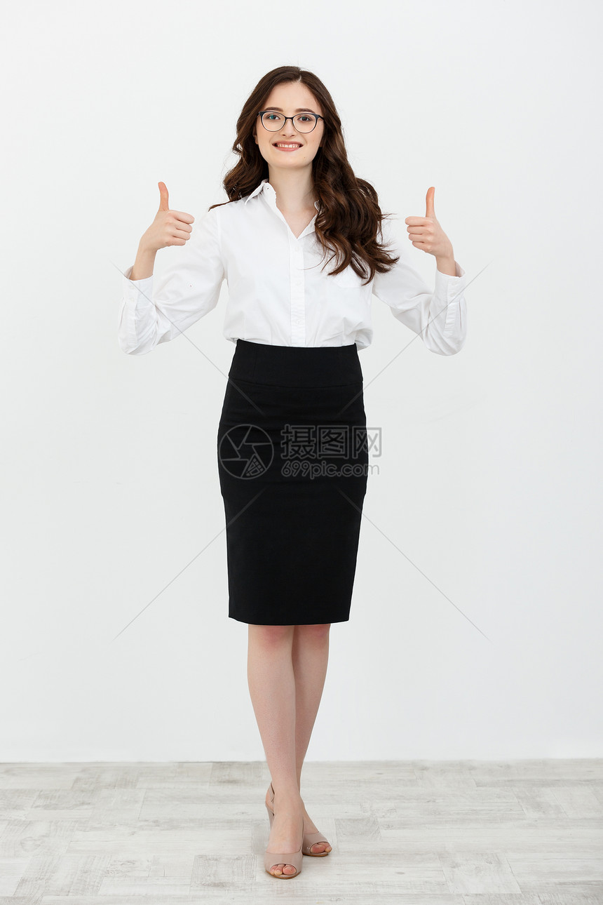 一个穿西装的漂亮女人完整肖像在白色工作室背景上留下一个拇指被孤立在白色工作室背景上一个穿着西装的漂亮女人完整肖像被白色工作室背景图片