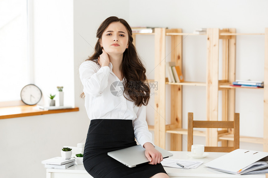 长期坐在办公室计算机桌的年轻女商人长期坐在办公室计算机桌的年轻女商人图片