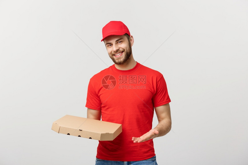 交付概念年轻大猩英俊的比萨饼送货员手持披萨盒与灰色背景隔开交付概念年轻大猩英俊的比萨饼送货员手持灰色背景隔开的比萨盒图片