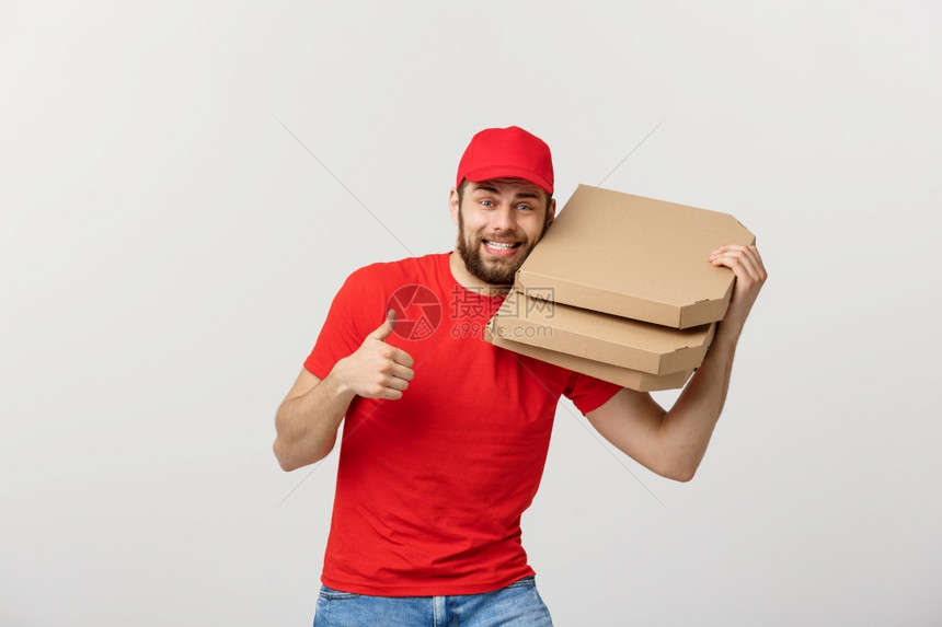 年轻英俊的送货员展示比萨盒并举起拇指标志孤立在白色背景上披萨送货概念年轻英俊的送货员展示披萨盒并举起拇指标志图片