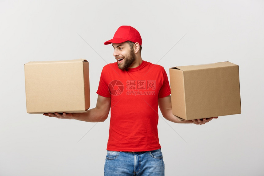 装着红色t恤的顶级送货员身穿红色t恤衫充当信使或经销商手持两个空纸板盒接收包件复制广告空间身着红色t恤的顶级送货员手持两个空纸板图片