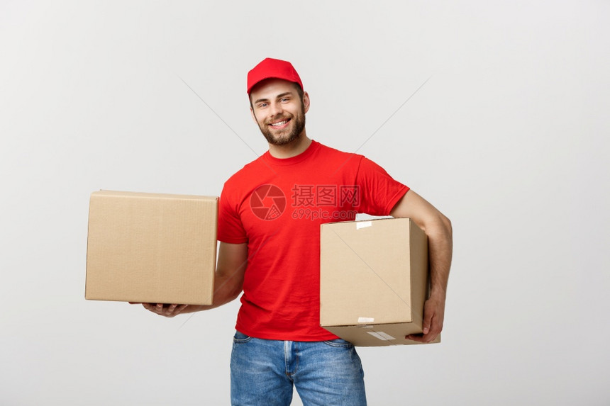 交付概念笑的英俊causin送货员拿着纸盒孤立于灰色背景图片