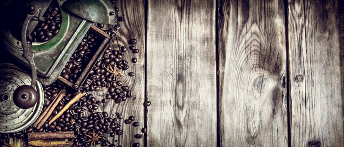 咖啡品味豆木制背景的老咖啡研磨机图片