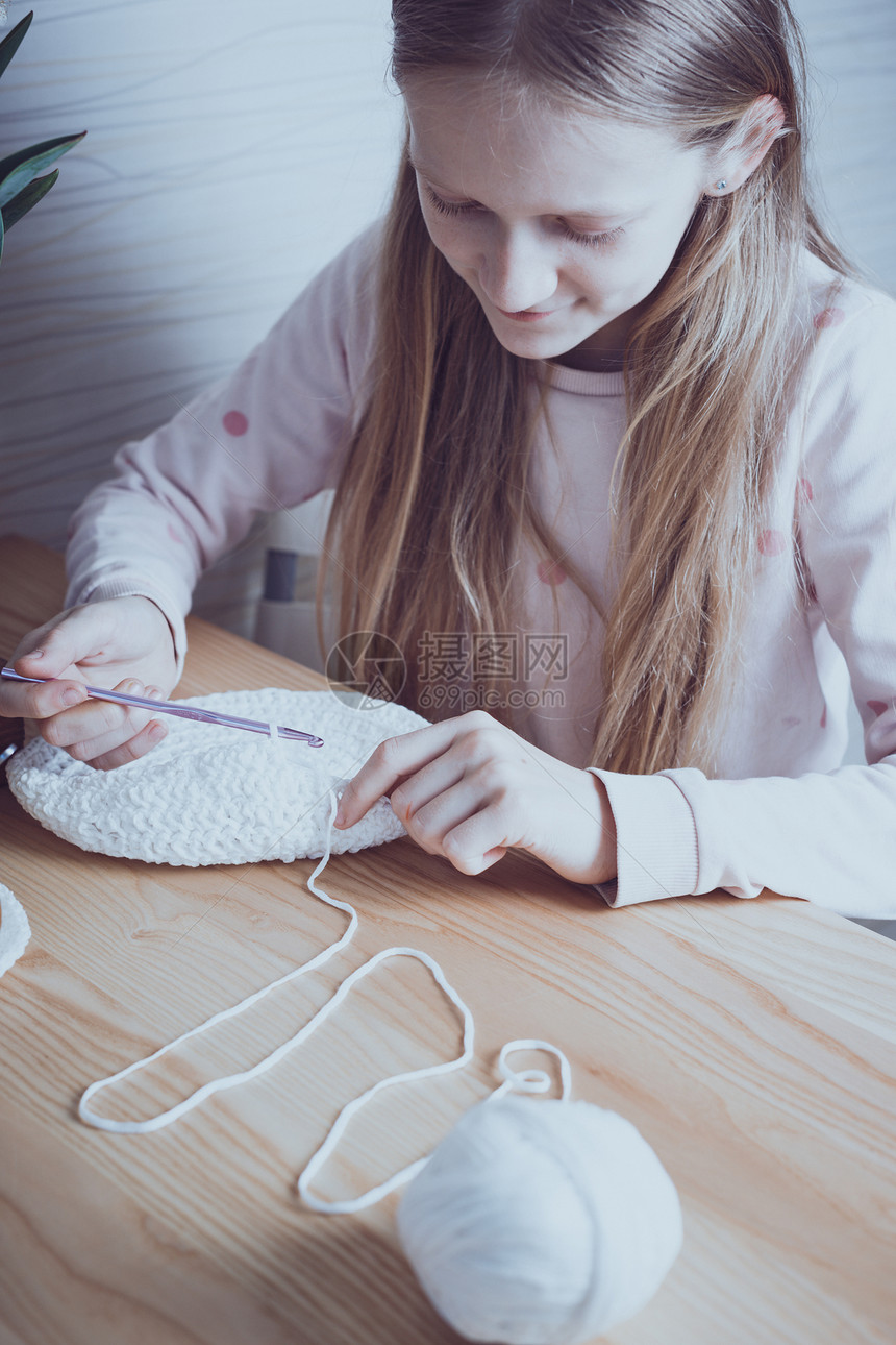 小女孩在编织地毯休闲和爱好缝纫图片