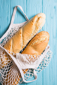 木制蓝底的法国袋式面包背景图片