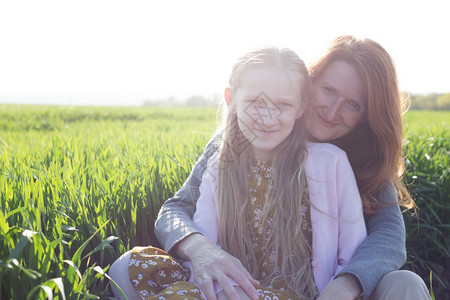 家庭幸福的母亲和女儿在草地上图片