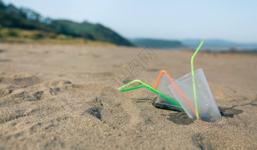 海滩风景有塑料杯和稻草在聚会之后有塑料杯和稻草海滩图片