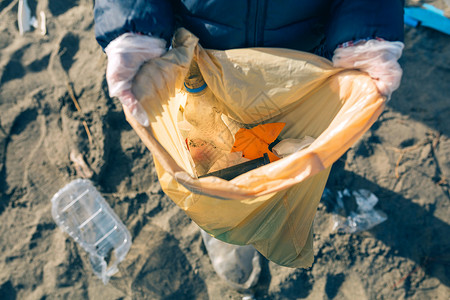 志愿者手素材装满从海滩收集的垃圾袋女童背景