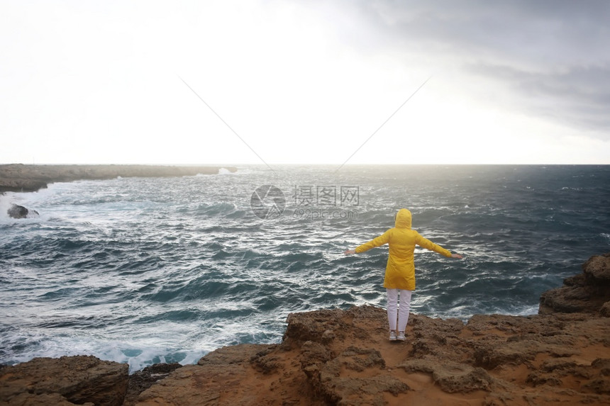 穿黄色雨衣的女子伸开手图片