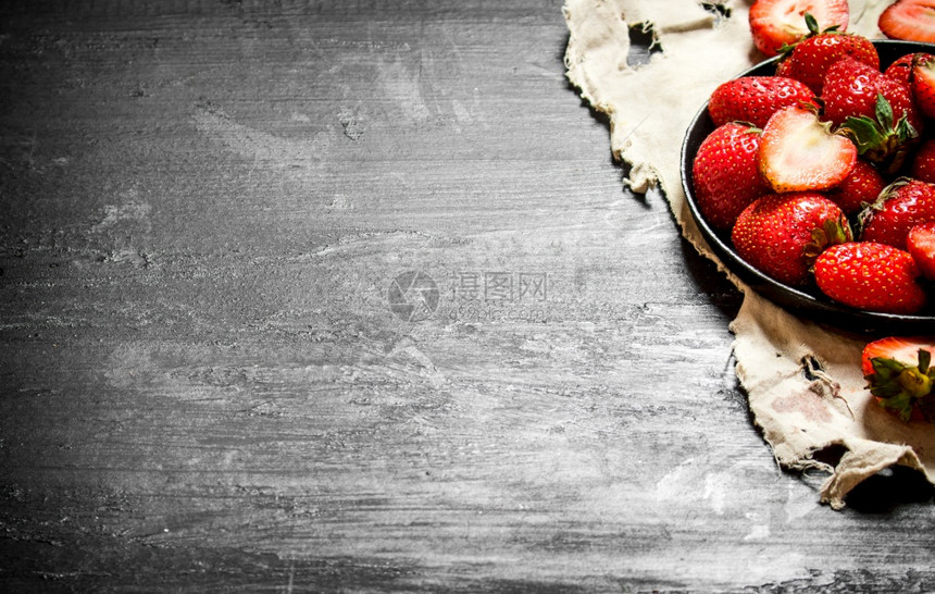 成熟的草莓旧盘子在黑木板上成熟的草莓旧盘子图片