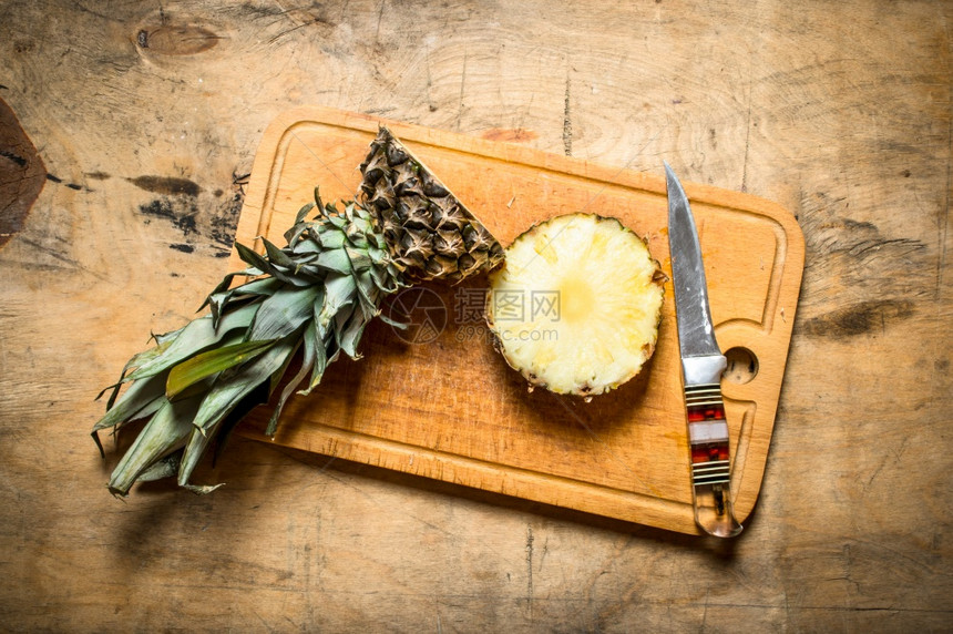 新鲜菠萝和刀子放在木制桌上新鲜菠萝和刀图片