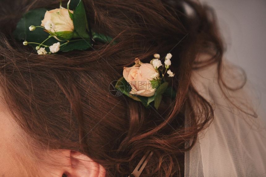 在新娘的头发上插粉红色花朵图片