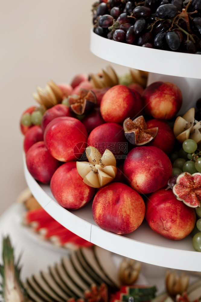 餐桌上的盘子不同种类的新鲜水果带桃子葡萄和无花果的水背景有选择的焦点桃子葡萄和无花果的水背景有选择的焦点图片