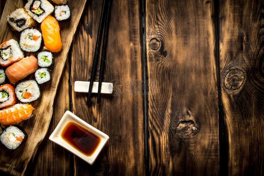 寿司和卷黄油的海产食品木制背景图片
