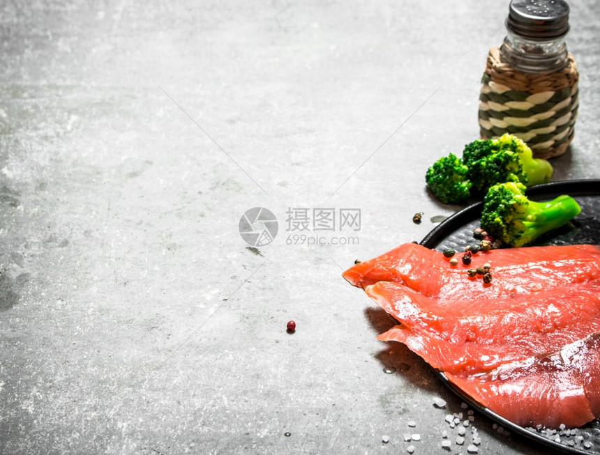 一块有西兰花和盐的熏鲑鱼片图片