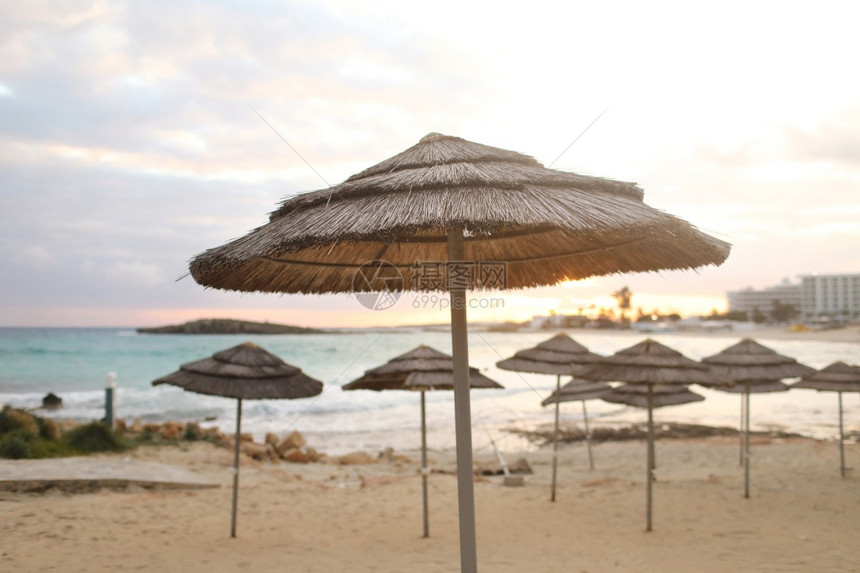 空海滩上的美丽草伞明亮蓝水和天空堂热带海滩放松的时间令人叹为观止的景色没有人日落的背景选择焦点海滩上美丽的草伞空海滩上美景日落的图片