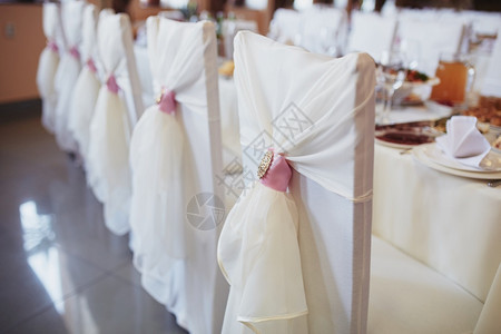 餐厅的婚礼椅子装饰有白布和金胸针有选择地聚焦结婚日席装饰有白布和金胸针装饰婚礼日节桌装饰有选择地聚焦背景图片