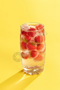 黄底带冻草莓的玻璃水冷和冰果图片