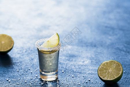 龙舌兰酒柠檬片和盐蓝色的桌子背光美味的墨西哥饮料一杯酒精暑期派对饮料图片