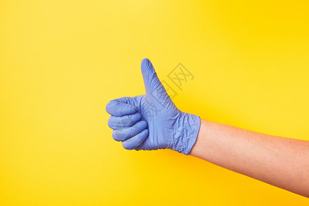 女手放在紫色橡胶保护手套上显示黄色背景上的符号ok复制空间防止细菌和的概念签名女手放在橡胶保护套中的标记背景图片