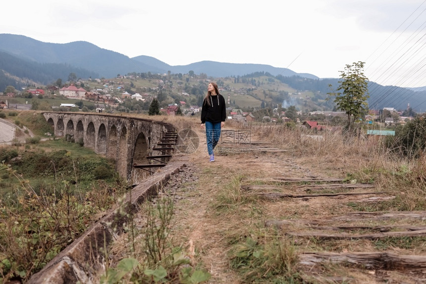 旅游少女在这条管道上走旧铁路在vorhta山村的老铁路道上走图片