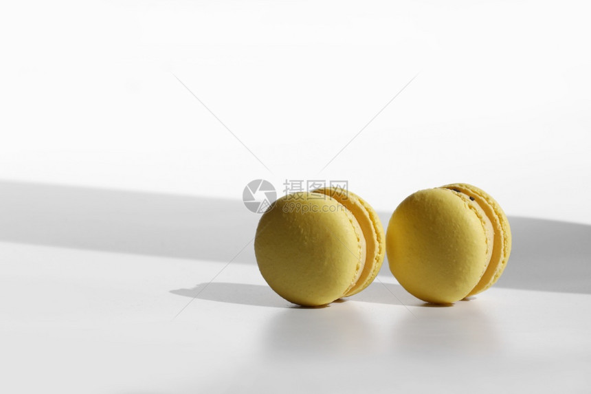 黄色马卡龙或的抽象模式白色背景的黄马卡龙或有阴影无缝模式美味健康的法式甜点创造最低限度现代概念黄色马卡龙或有阴影的白色背景马卡龙图片