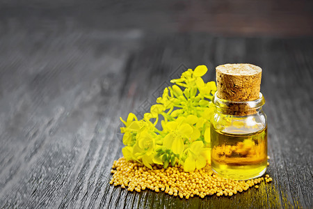 玻璃瓶中的芥子油木板底的谷物和黄花高清图片