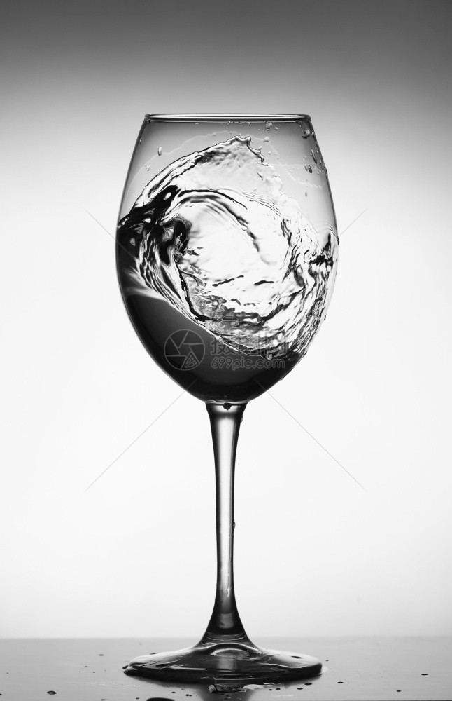 在玻璃酒杯中喷水在发光背景上喷水在酒杯中以透明方式喷水在酒杯中食物品在玻璃杯中喷水物品图片