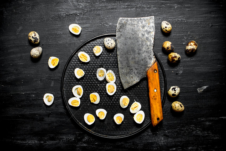 斧头和煮熟的鹌鹑蛋在盘子上图片