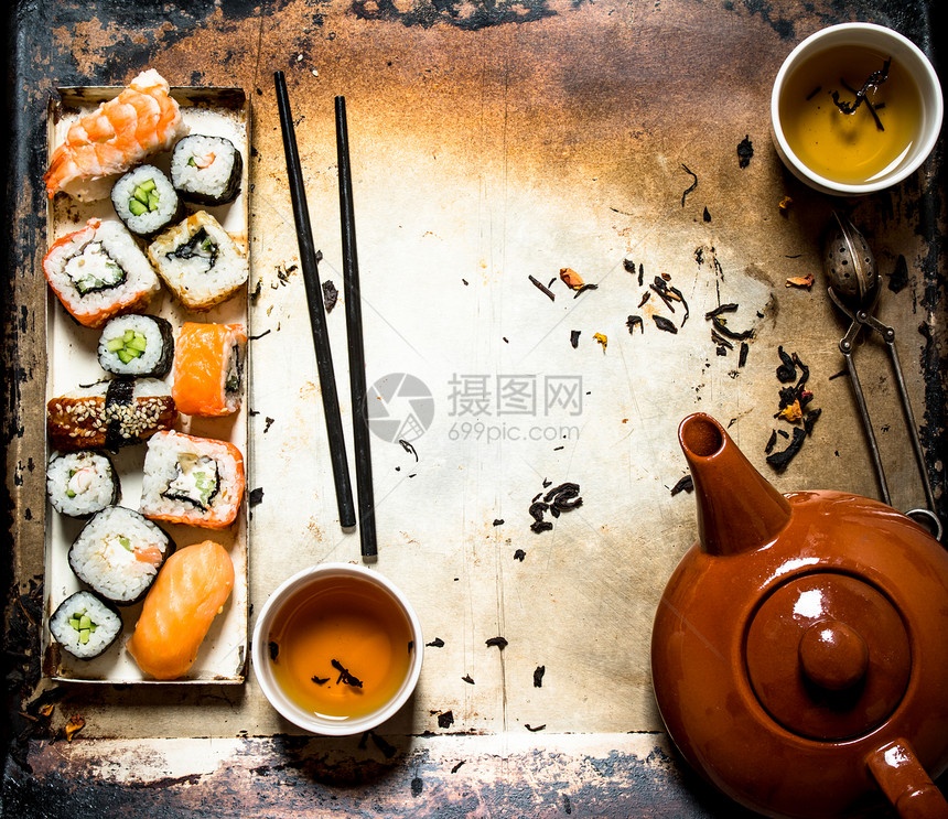 寿司和香草茶卷药以古老的生锈背景寿司和草药茶卷图片