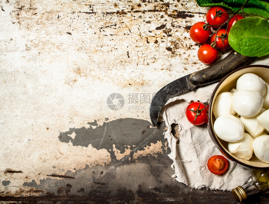 乳酪西红柿橄榄油和一把旧刀以生锈背景橄榄油和一把旧刀图片