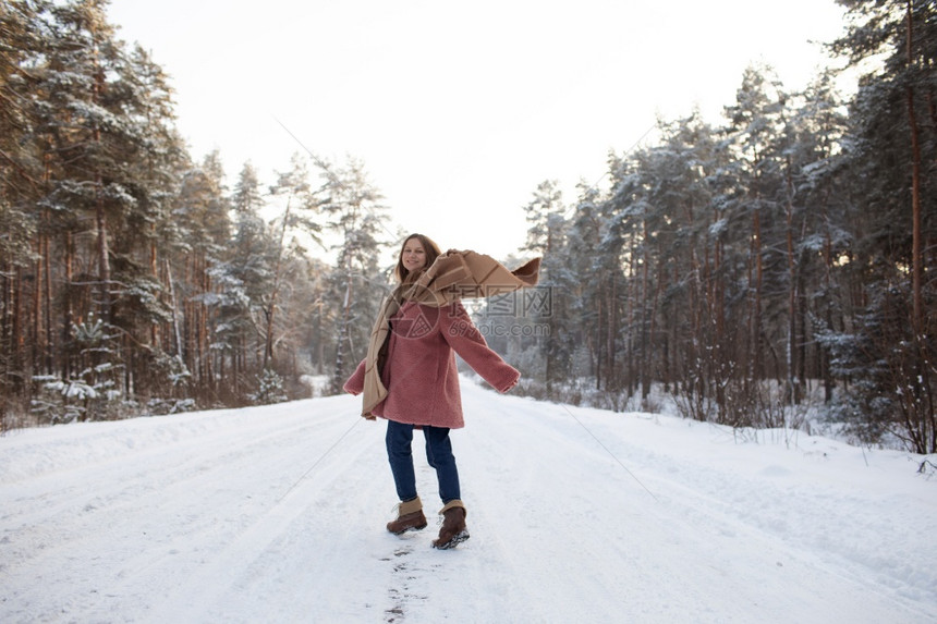 年轻时髦的女人在冬季雪林里玩得开心年轻时髦的女人在冬天雪林里玩得开心图片