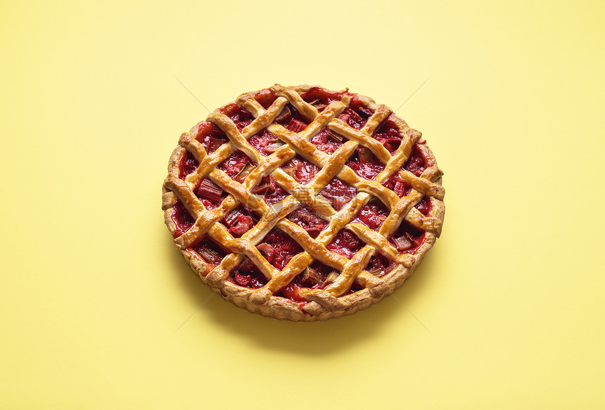 草莓rhuba派上面是黄色无缝背景的花边壳整块馅饼上面是夏季水果填料英国传统派图片
