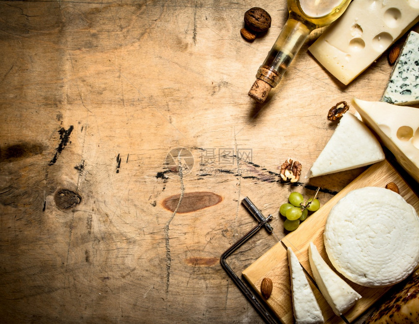 白葡萄酒和不同种类的奶酪图片