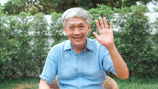 亚裔年长男使用手机视频电话与家庭孙子女儿童交谈图片