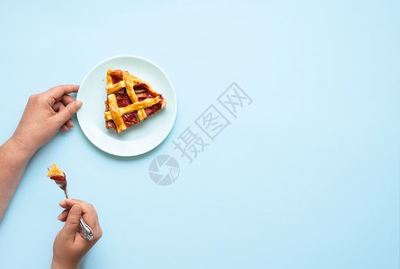 蓝色背景上吃一块粗巴和草莓馅饼一个女人吃块粗巴蛋糕美味的德国甜点图片
