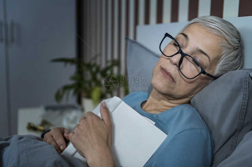 睡着成年女人戴眼镜胸前有一本书图片