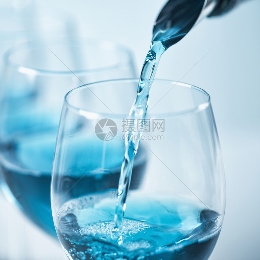 盛满蓝色葡萄酒喷出水泡和倒入葡萄酒杯中关上图片