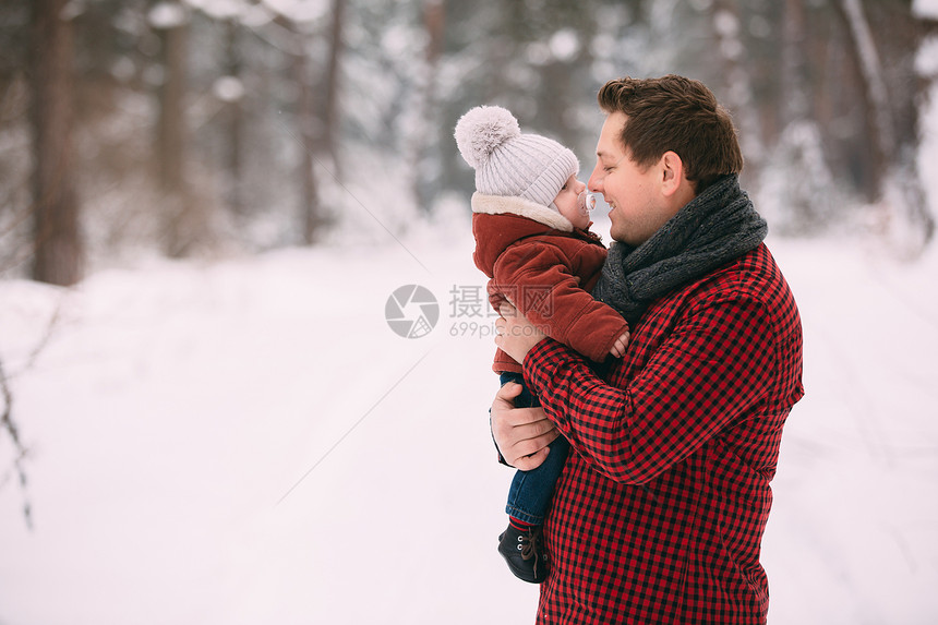 快乐的爸和小儿子肖像在冬季森林里玩乐复制空间在冬季森林里玩乐复制空间图片