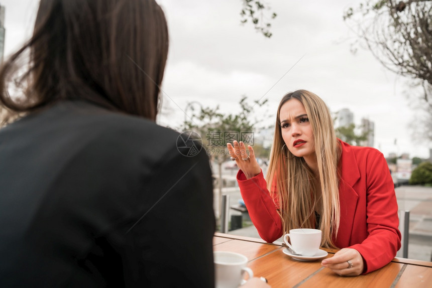 两位愤怒的朋友在咖啡店聊天和讨论时图片