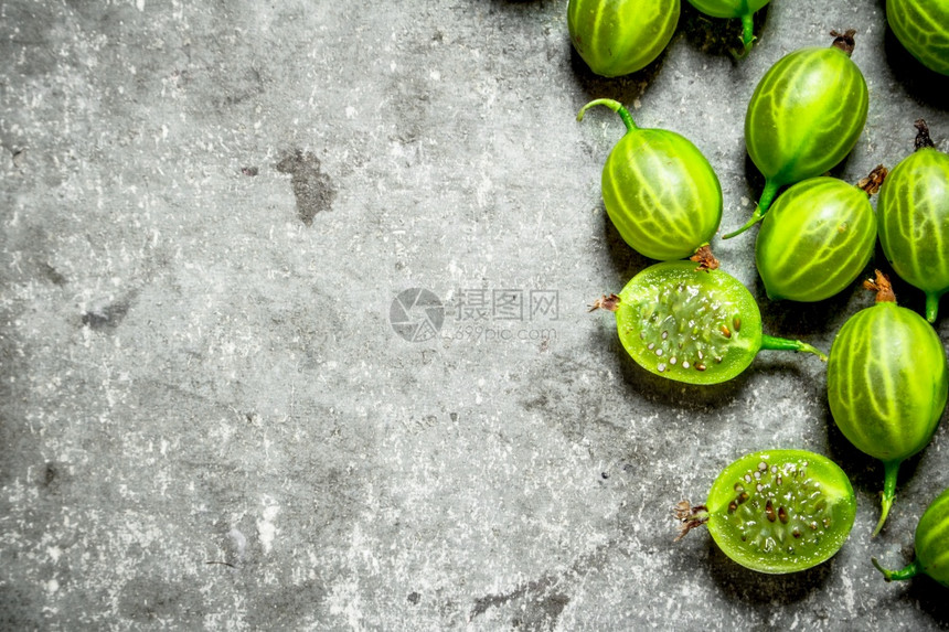新鲜的绿鹅莓以石头为背景图片