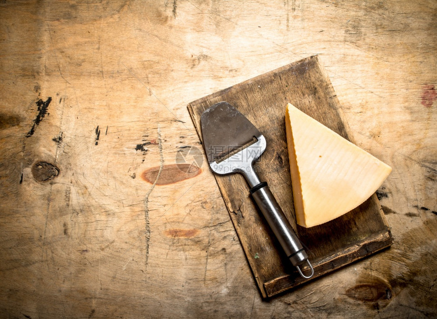 干酪奶和刀在旧的切割板上干酪奶和刀在旧的切割板上图片