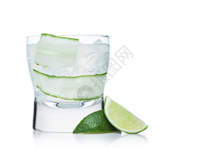 现代玻璃中的鸡尾酒上面有冰块和稻草黄瓜石灰片白色底面有石灰边图片