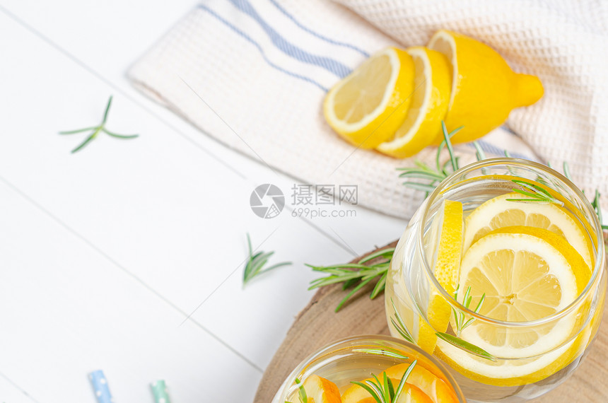 柠檬汁在罐子里柠檬水和露天桌上有迷迭香的柠檬图片