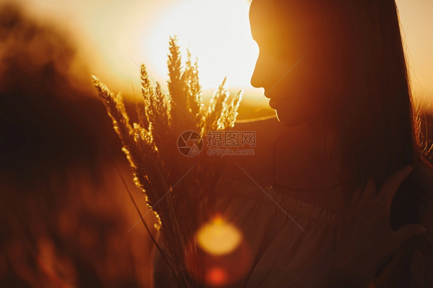 春日落夏风景女孩在田野中夏日地貌女孩在田中春日落时美丽的微笑女人在田地上有选择关注图片