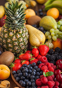 木质盘和本底的外来水果中新鲜有机夏季果子混合物和异国水果草莓蓝黑和樱桃西瓜梨菠萝葡萄背景图片